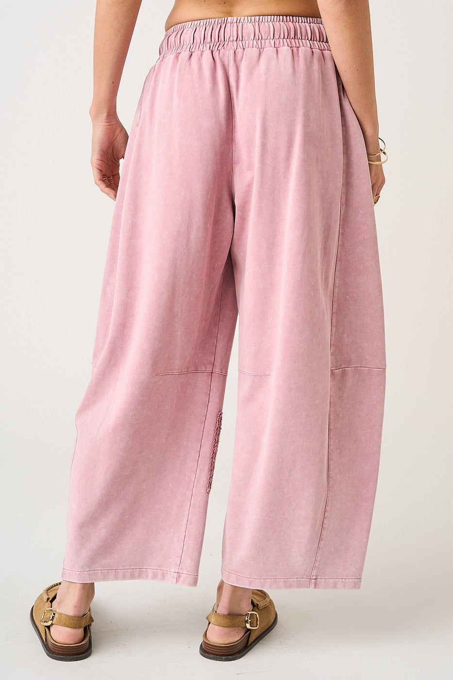 Pink wide-leg pants worn by a person on a white background