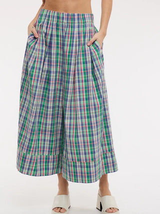 Multicolored plaid wide-leg pants worn by a person on a white background