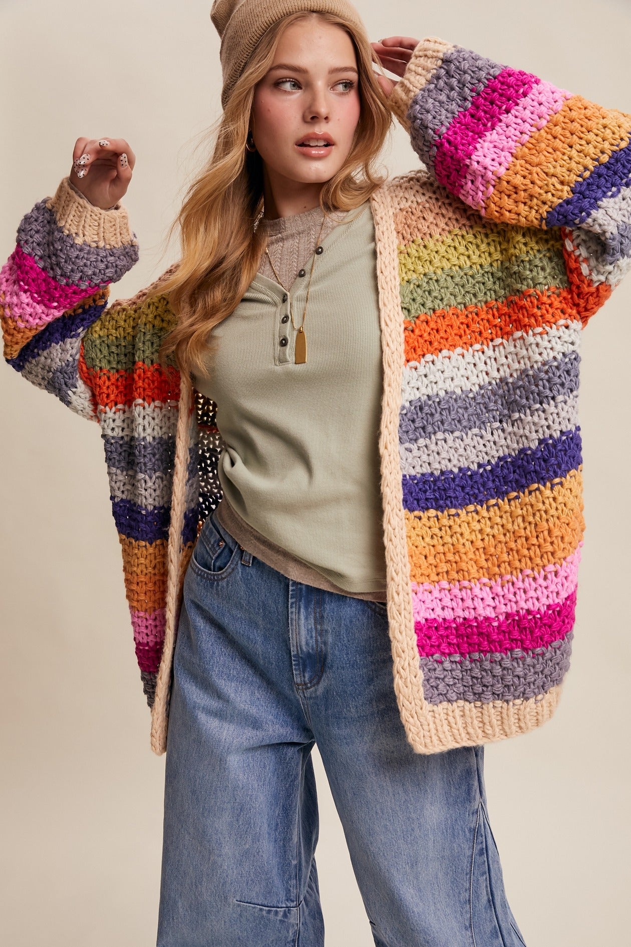 Woman wearing a colorful striped cardigan against a neutral background