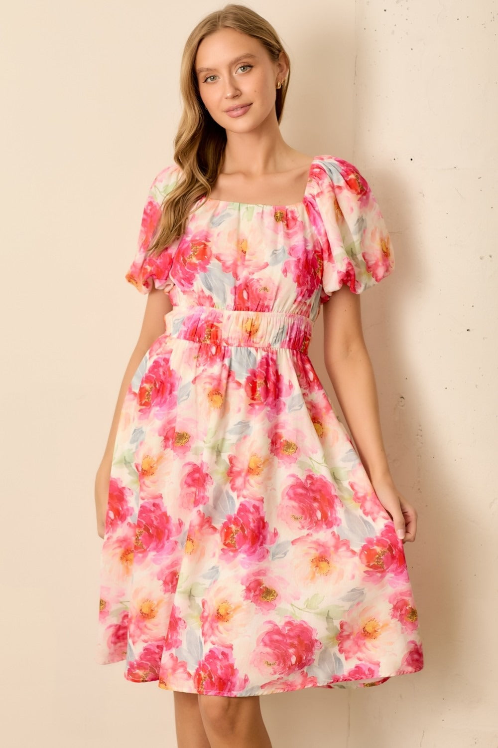 Woman wearing a floral dress against a beige background
