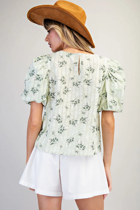 Women wearing a green floral blouse with white shorts