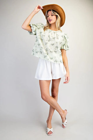 Women wearing a green floral blouse with white shorts