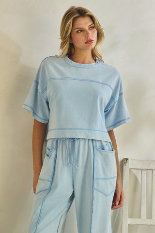 Woman wearing a light blue outfit with a plain background