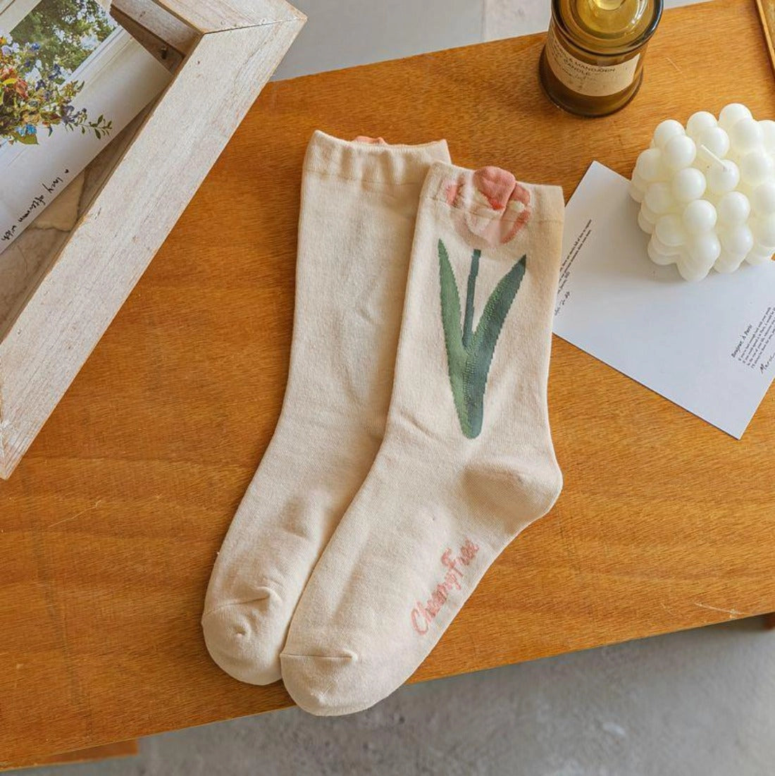 Beige socks with floral design on a wooden surface