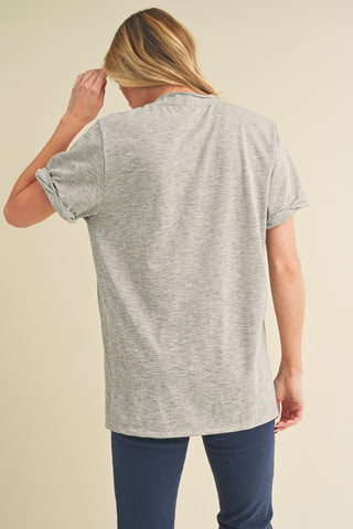 Woman wearing a gray t-shirt and blue pants on a beige background