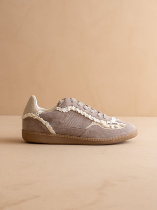 Gray sneaker with lace details on a beige background