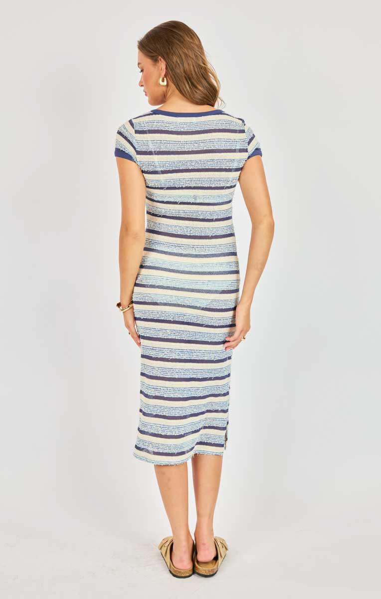 Woman wearing a striped dress on a plain background