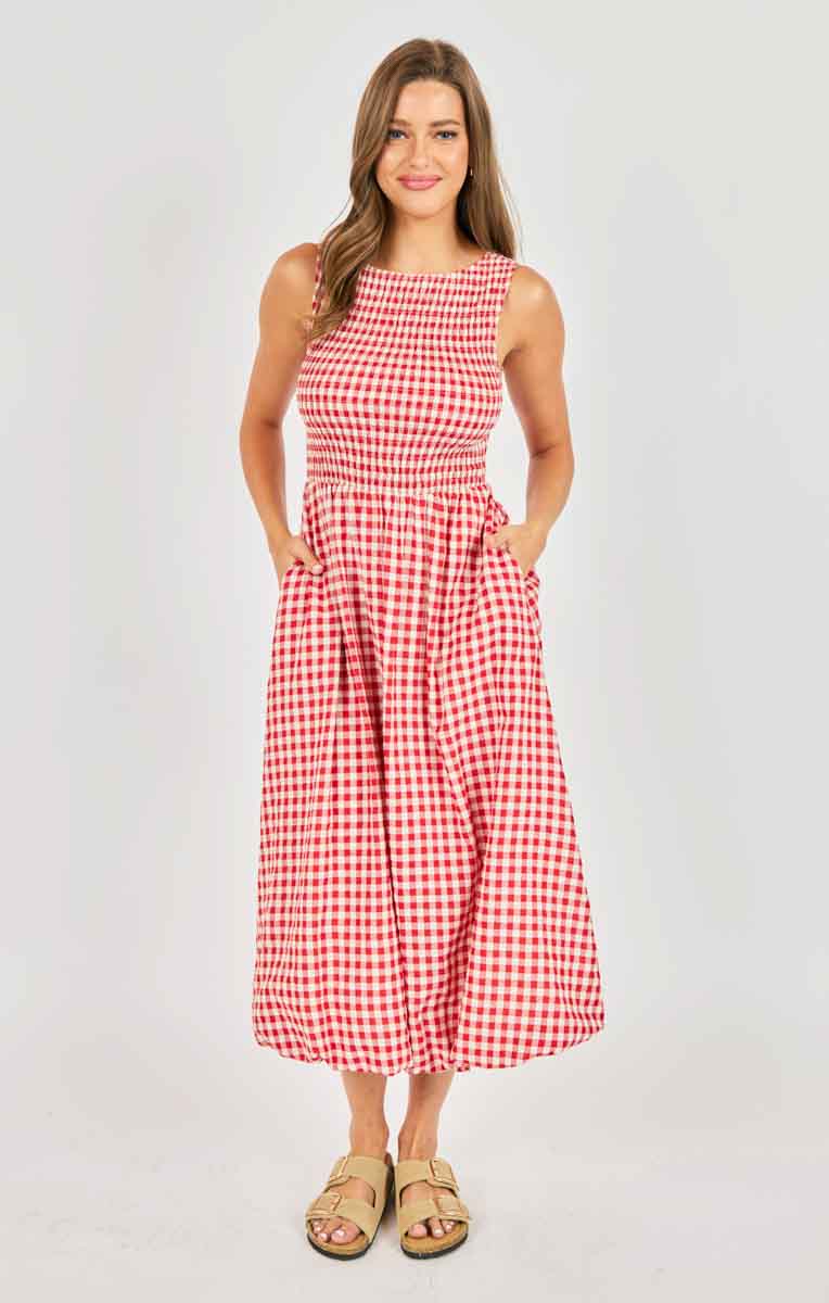 Woman wearing a red and white checkered dress against a plain background