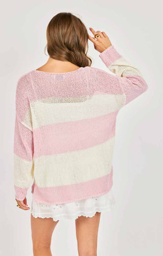 Woman wearing a colorful striped sweater on a white background