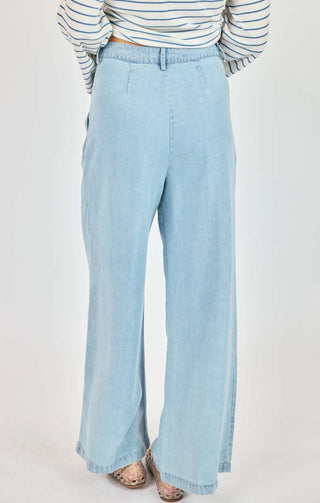 Light blue wide-leg jeans worn with a striped shirt on a white background