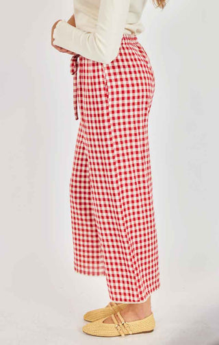 Red and white checkered pants worn by a person on a plain background