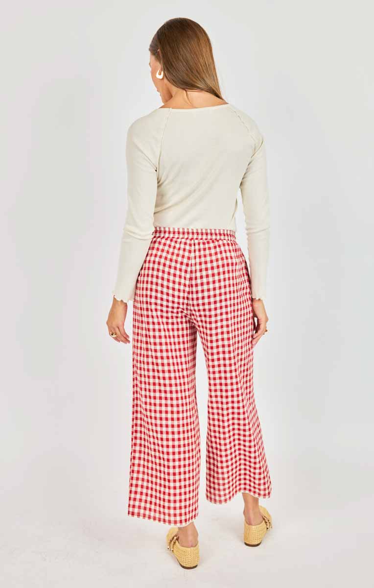 Woman wearing red and white checkered pants on a white background