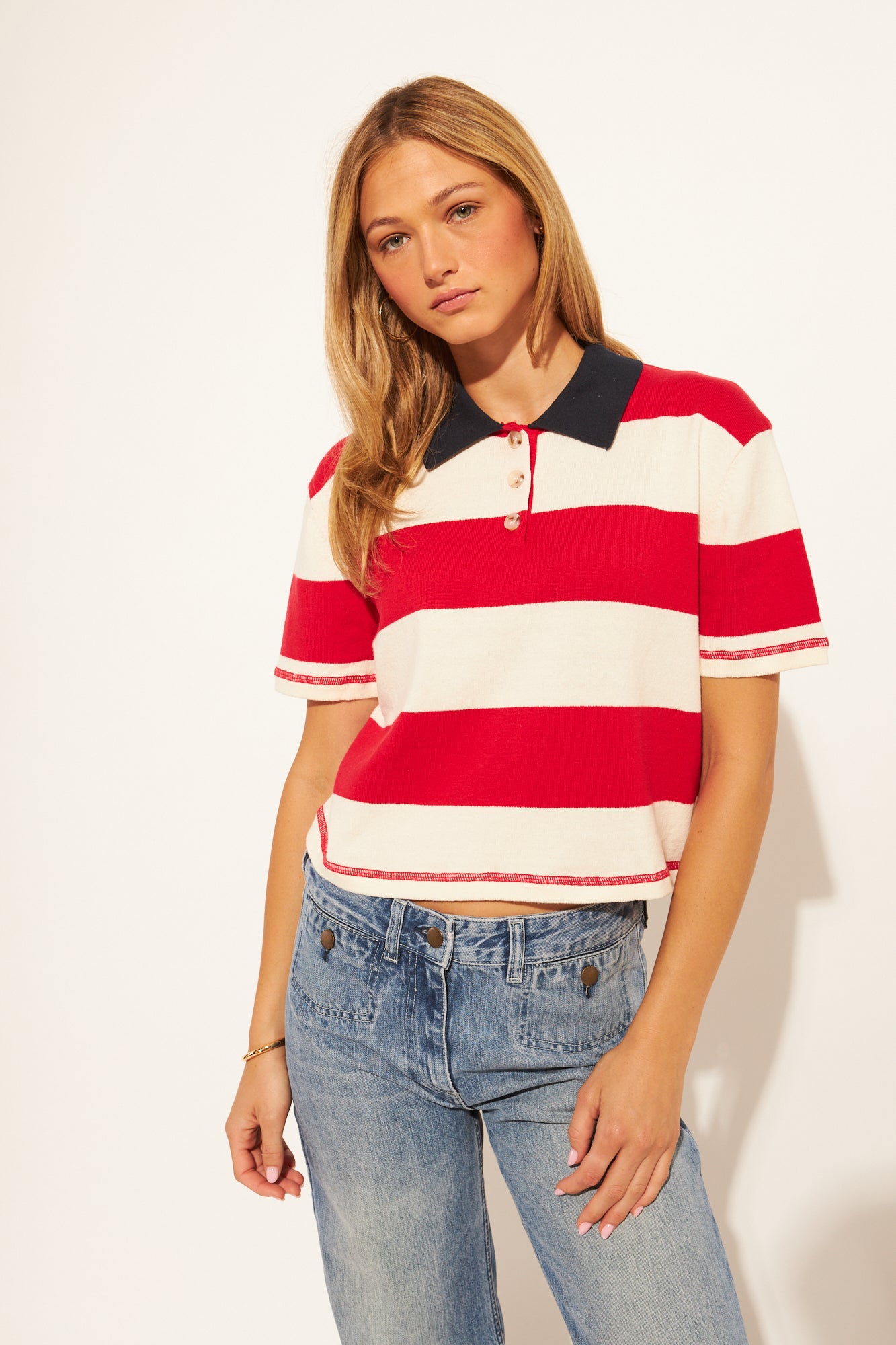 Women wearing a red and white polo crop top with a navy collar