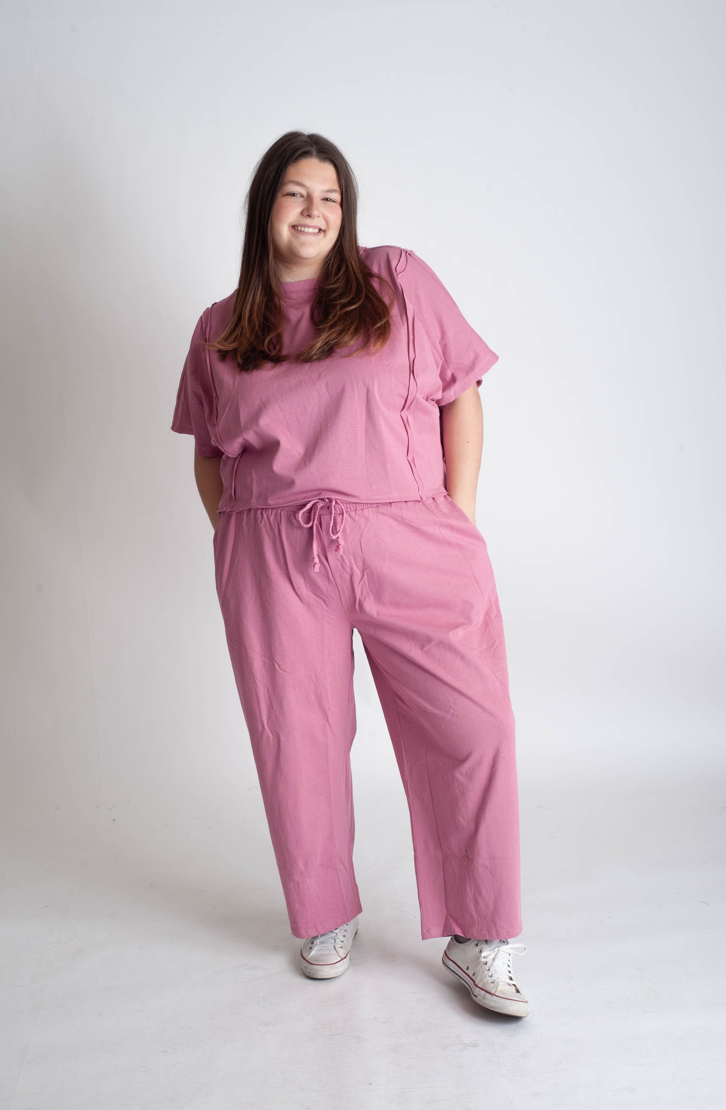 Person wearing a pink outfit on a white background