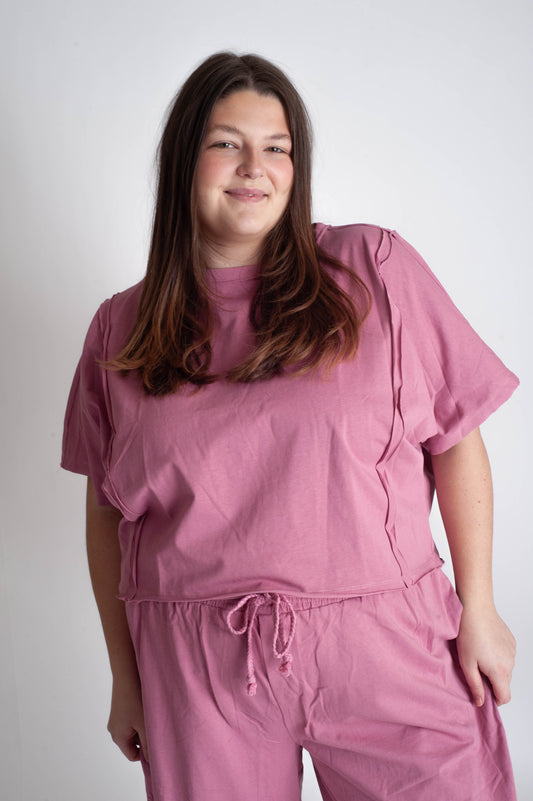 Woman wearing a pink outfit against a white background