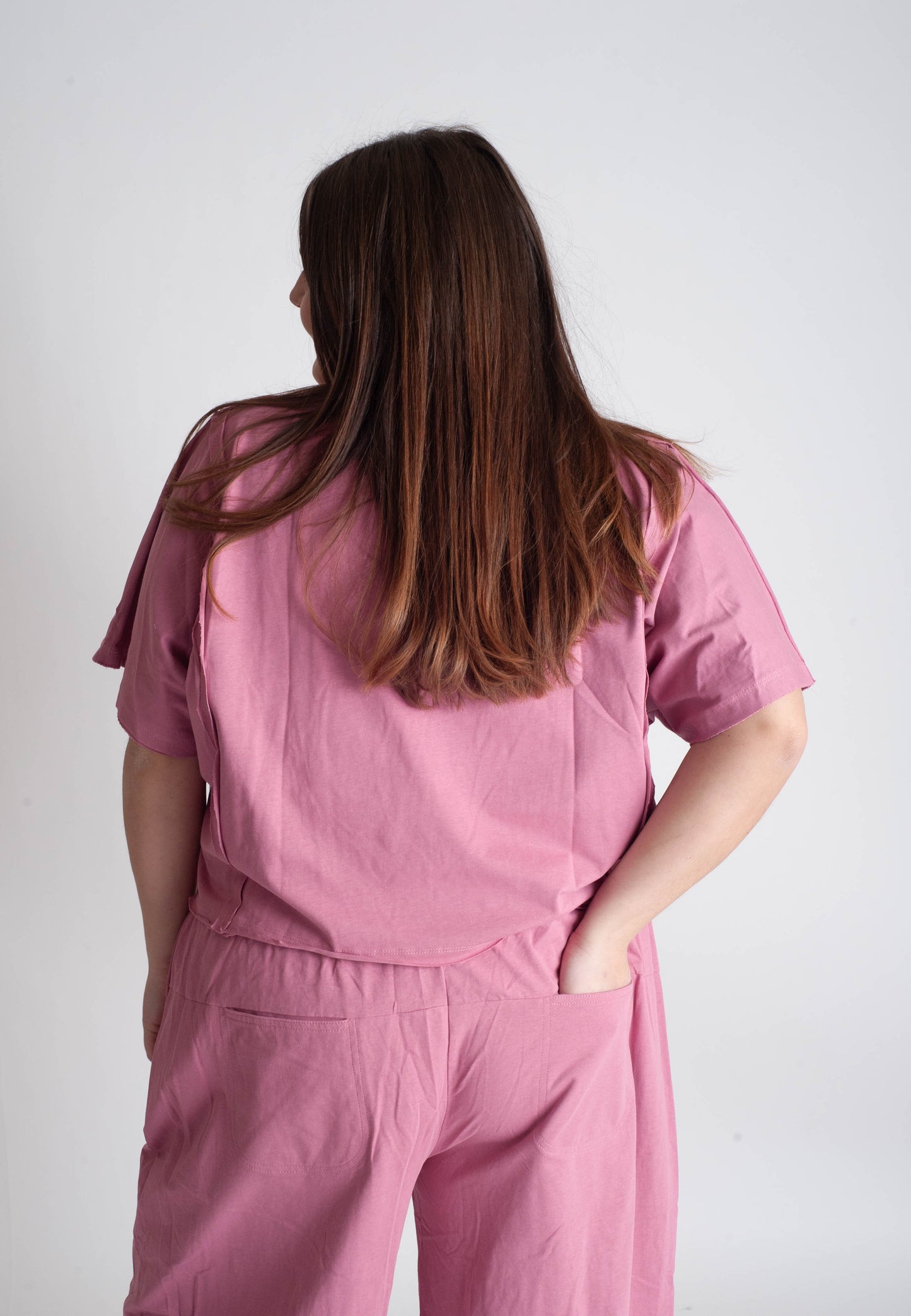 Person wearing a pink outfit against a white background