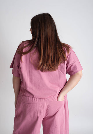 Person wearing a pink outfit against a white background