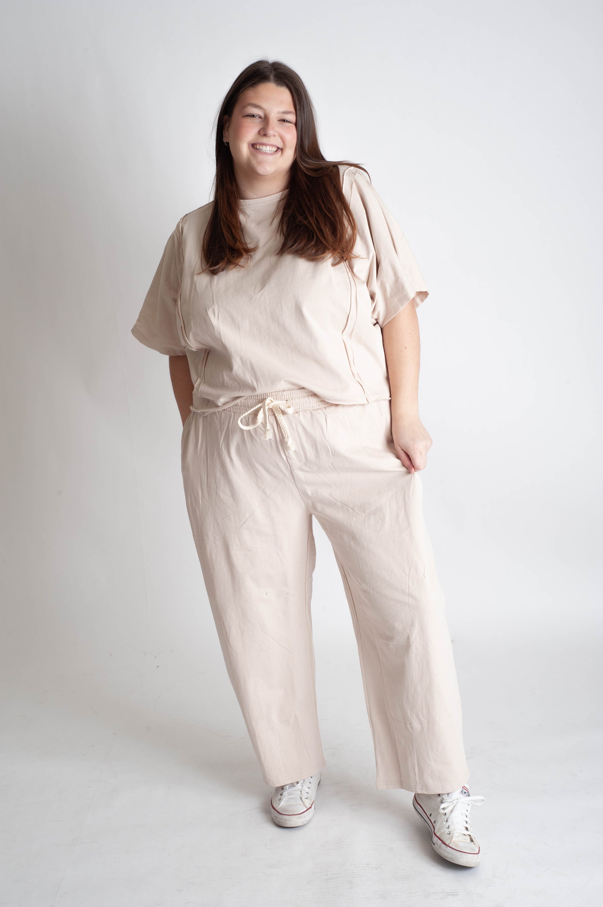Woman wearing a beige jumpsuit on a white background