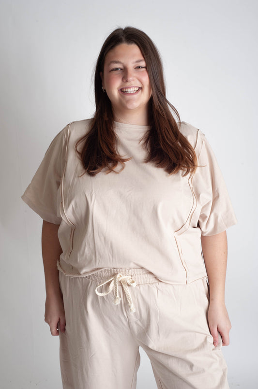 Woman wearing a beige outfit against a white background