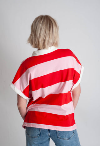 Person wearing a red and white striped shirt with a plain background