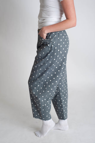 Person wearing gray polka dot pants on a plain background