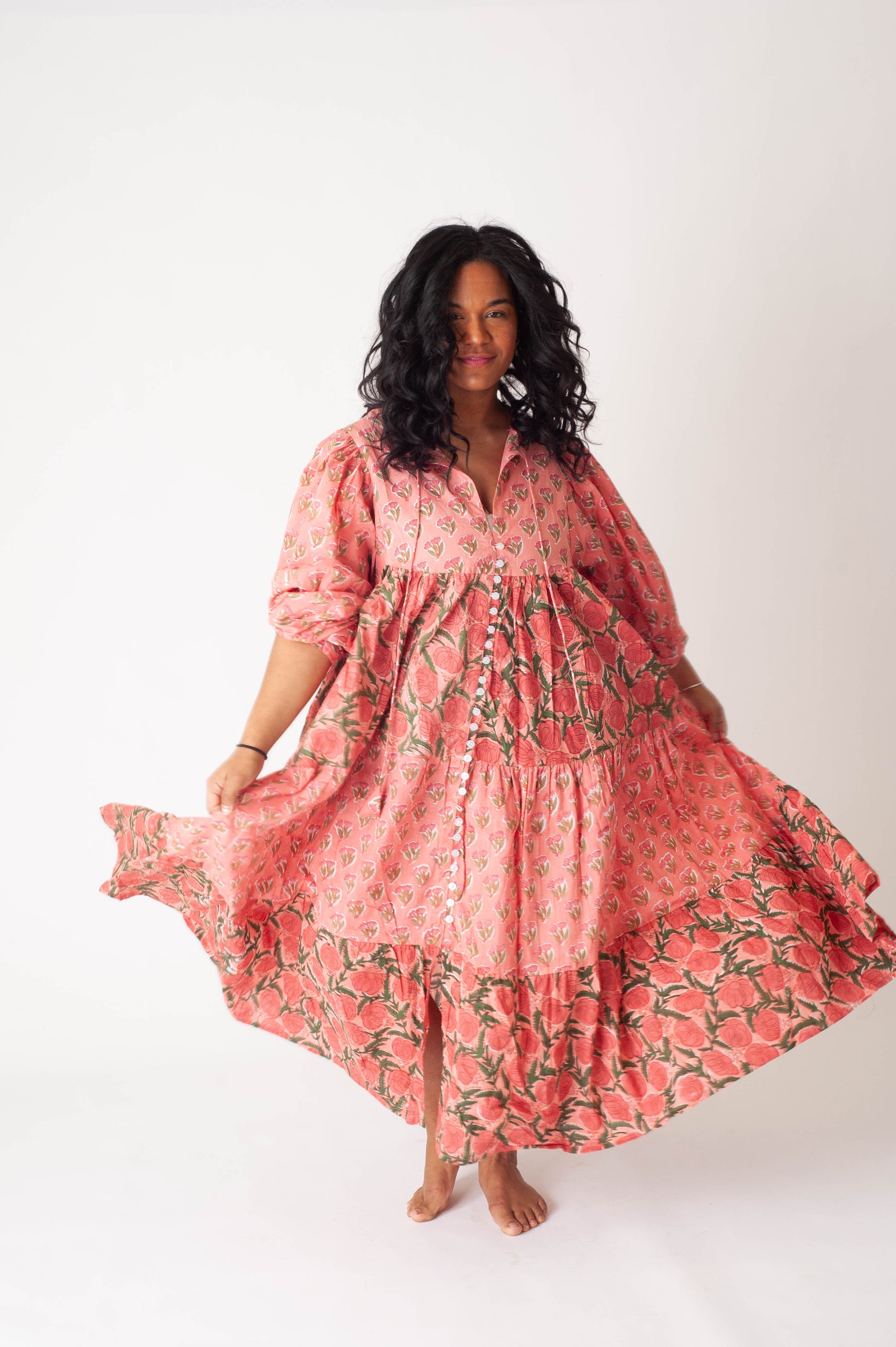 Woman wearing a pink floral dress on a white background