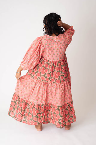 Person wearing a pink floral dress against a white background
