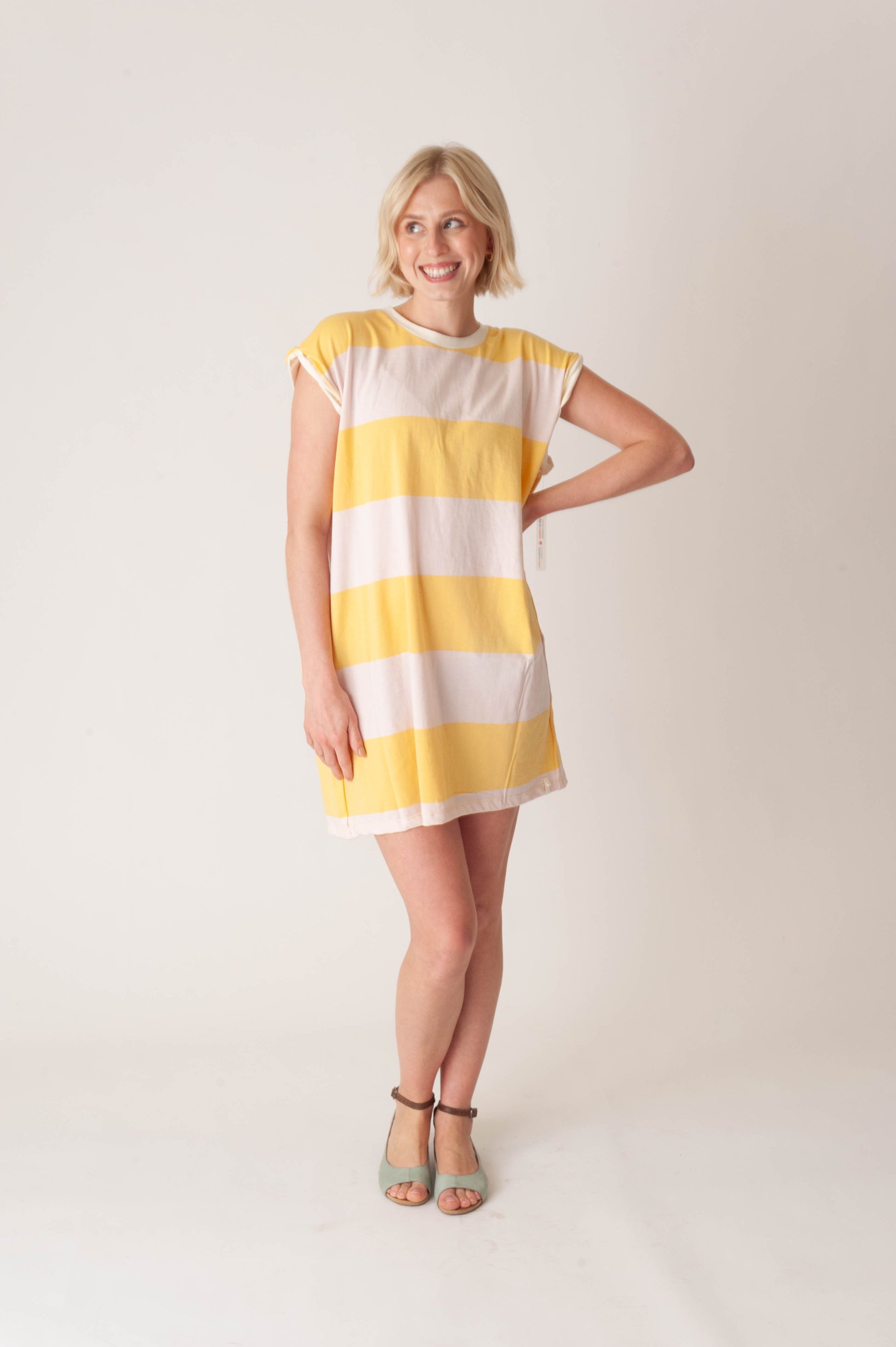 women wearing a striped yellow and pink dress on a white background