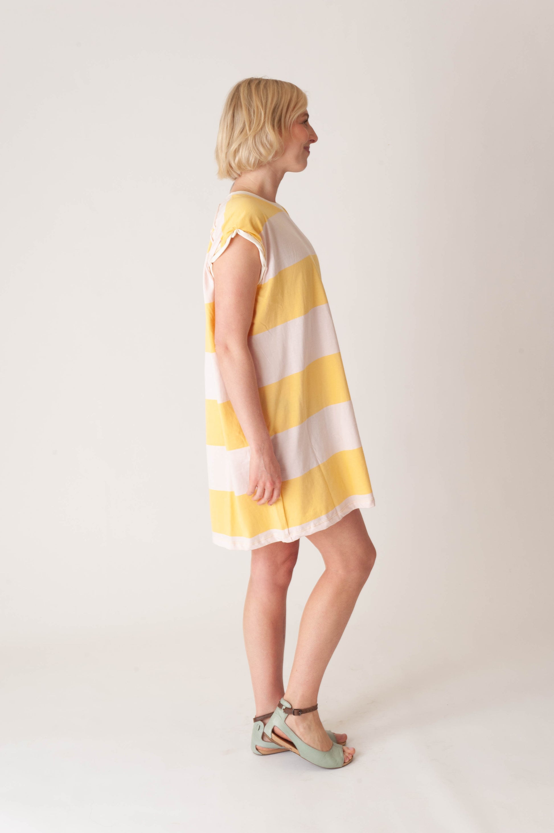women wearing a striped yellow and pink dress on a white background