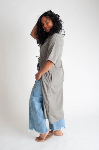 women wearing a button up dress on a white background.