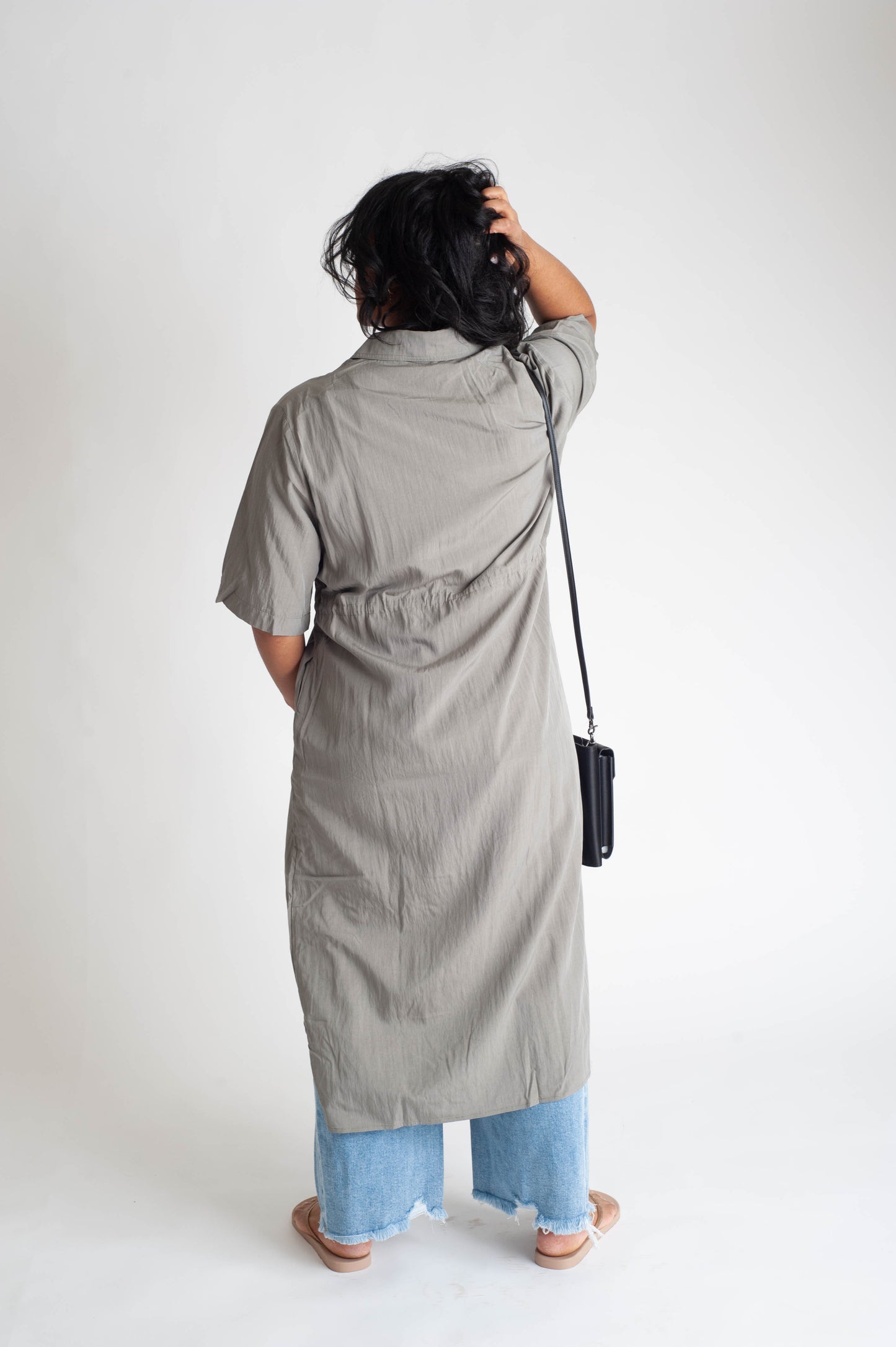 women wearing a button up dress on a white background.