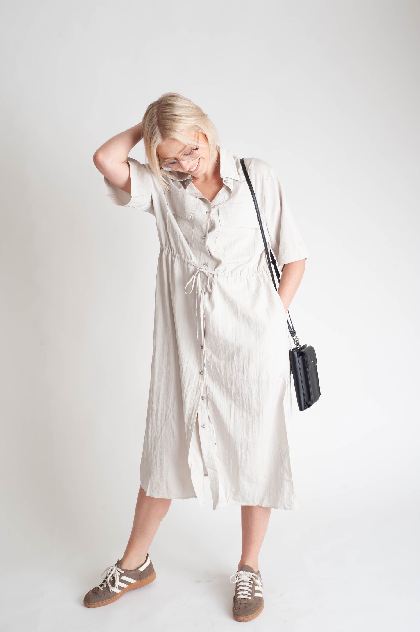 women wearing a button up dress on a white background.