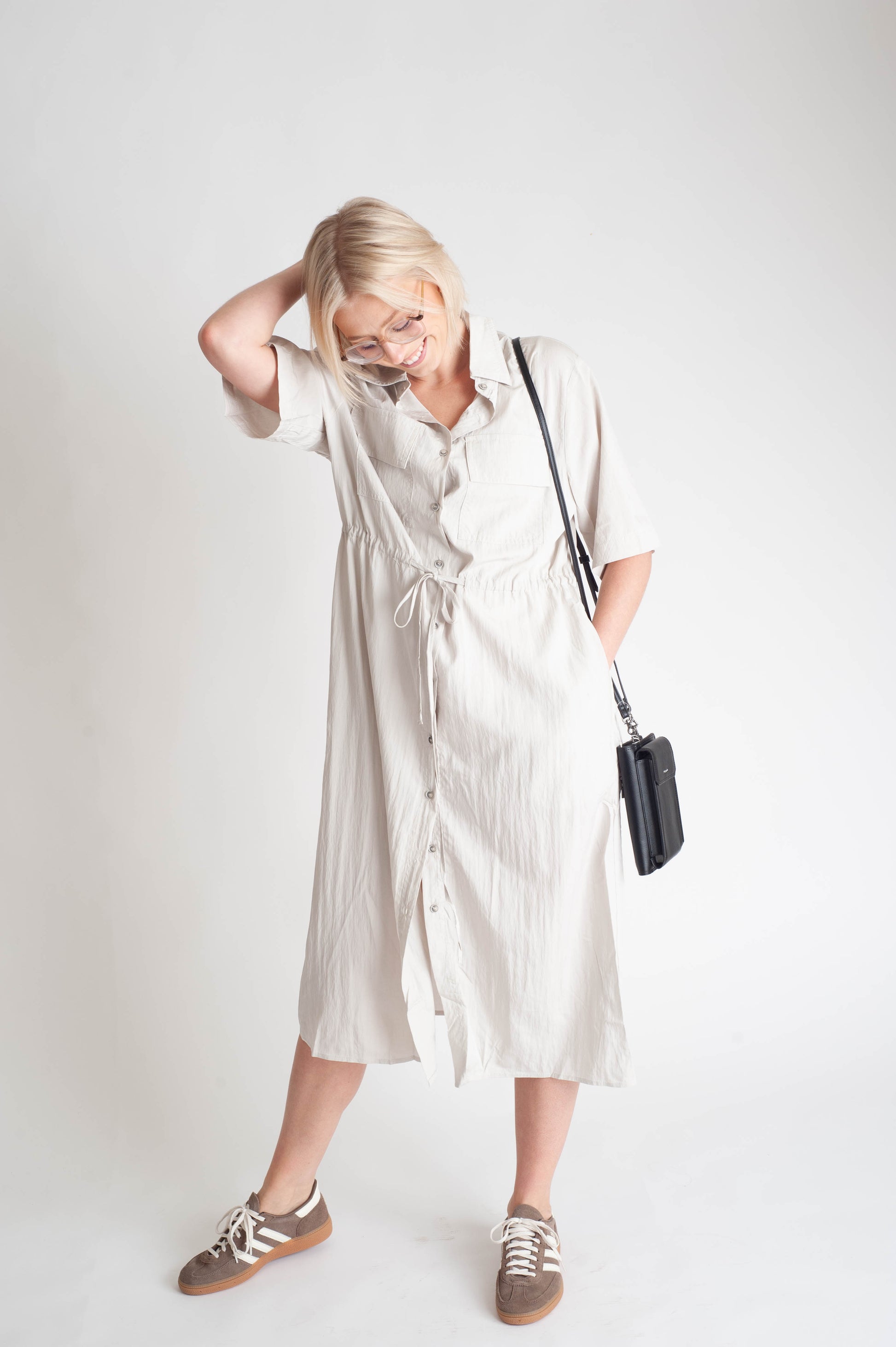 women wearing a button up dress on a white background.