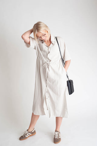 women wearing a button up dress on a white background.