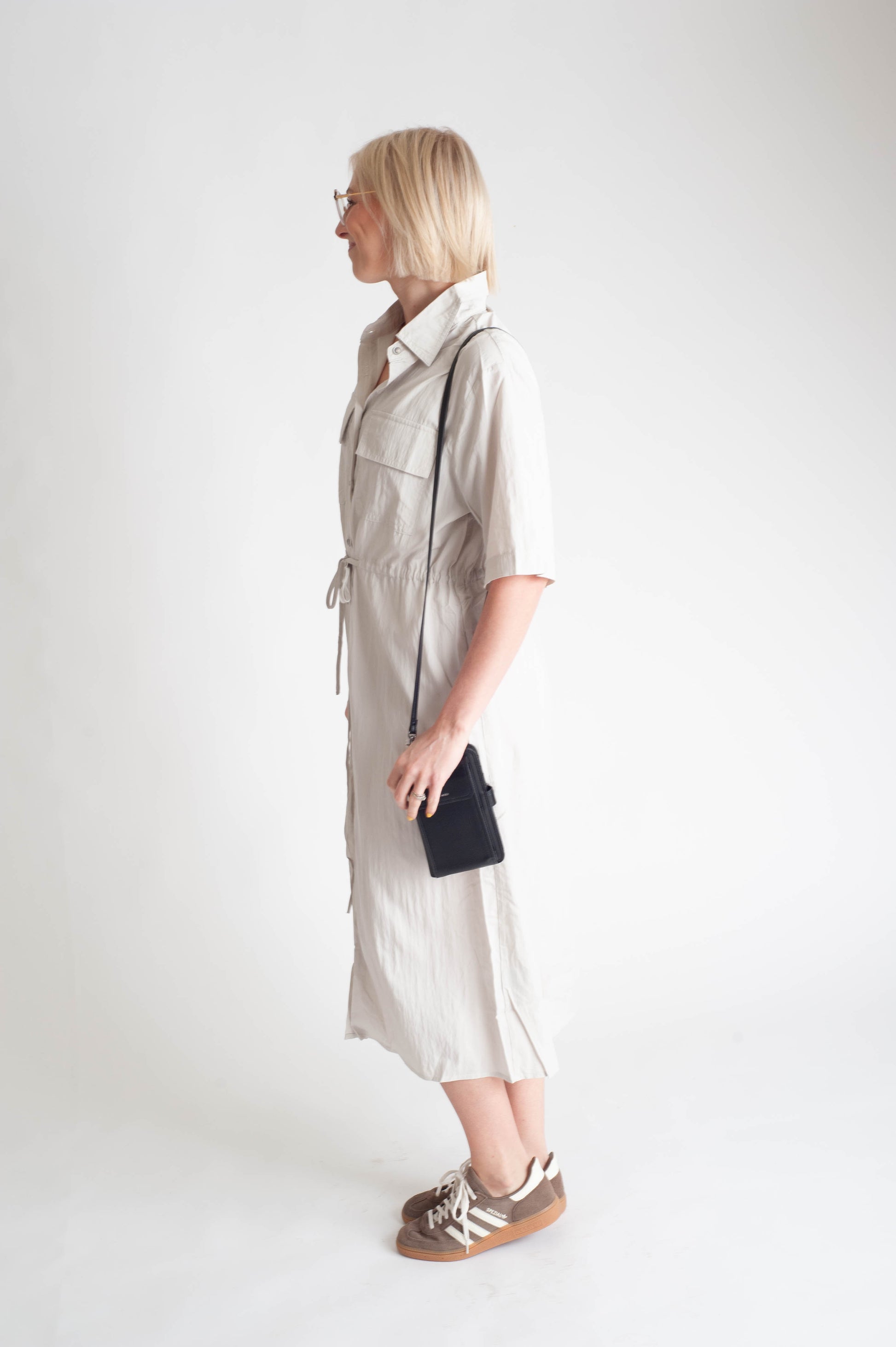 women wearing a button up dress on a white background.