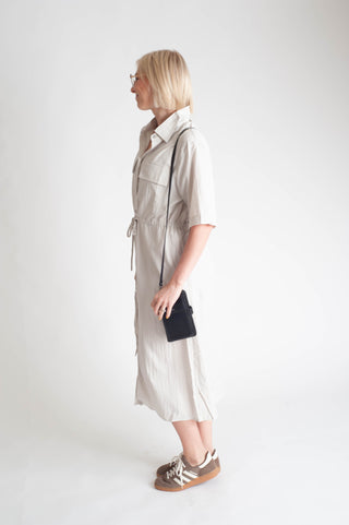 women wearing a button up dress on a white background.