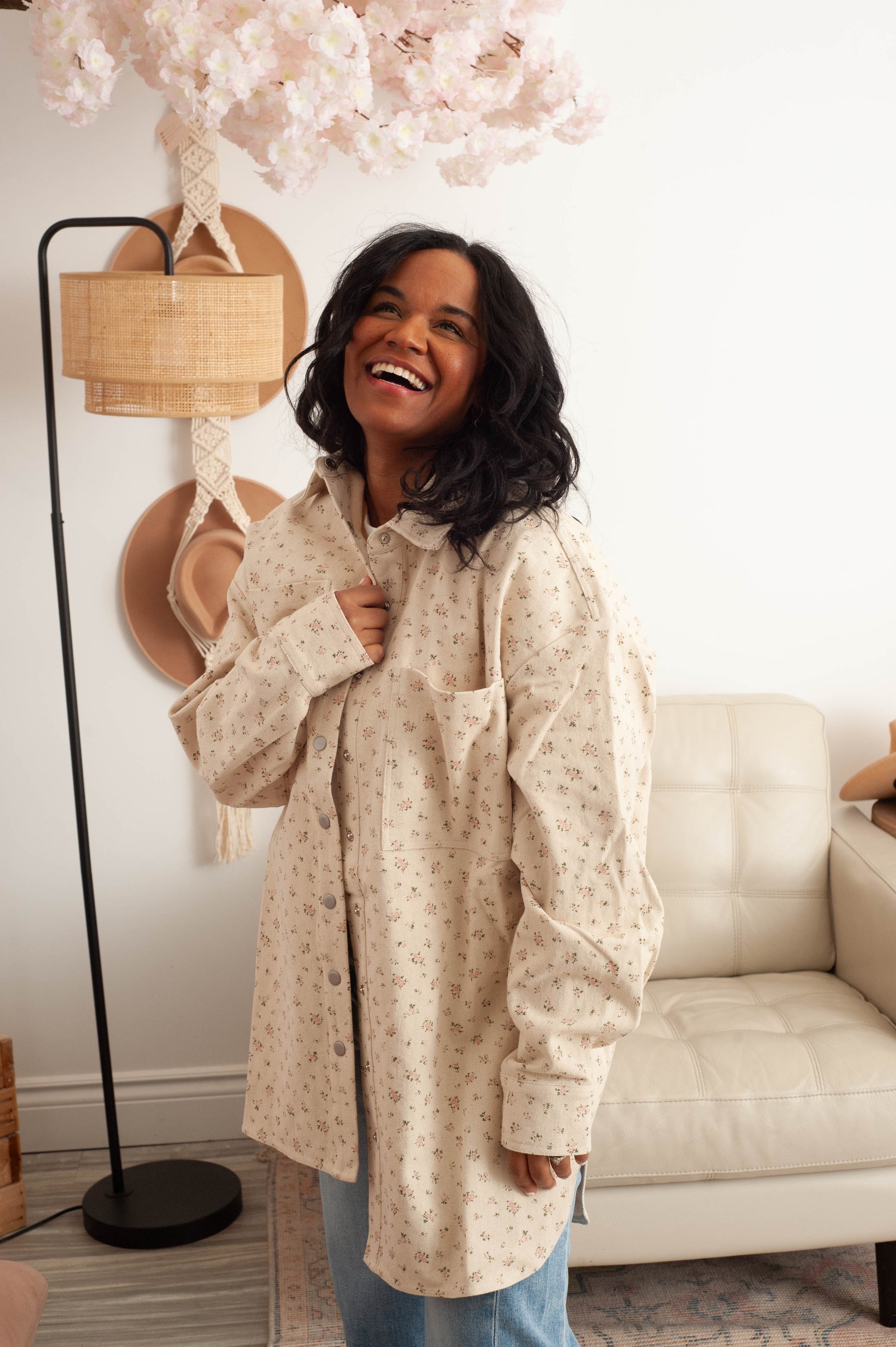 Woman wearing a long beige coat in a living room setting