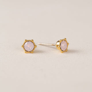A person wearing gold-plated brass crystal stud earrings.