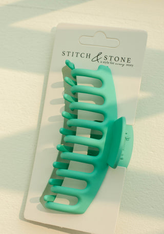 a plastic claw clip in a green colour