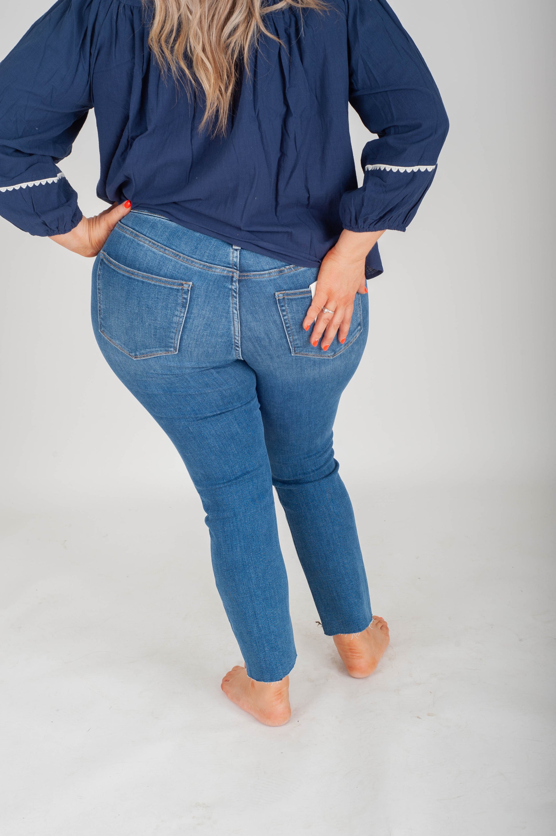 Person wearing blue jeans and a matching top on a white background