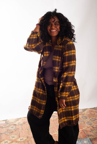Women wearing a yellow plaid coat against a white background. 