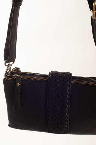 A close-up of a black leather shoulder bag featuring a prominent braided leather strap detail across the front and gold-tone metal hardware, set against a plain white background.