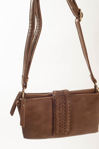 A brown faux-leather crossbody handbag with a braided strap detail on the front, a top zipper, and a shoulder strap, shown against a plain white background.