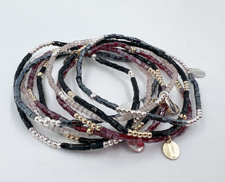Stack of beaded bracelets on a light gray background