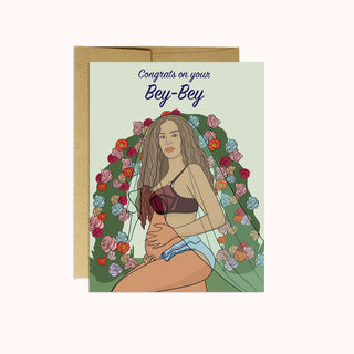 A greeting card with a illustration of a pregnant woman with flowers around her. The text on the card reads 'Congrats on your Bey-Bey'.