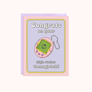 A pink and purple card with a tamagotchi on it. 