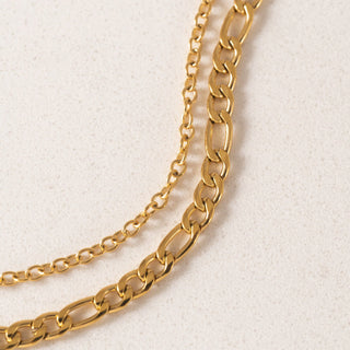 Gold chain necklace on a light beige background