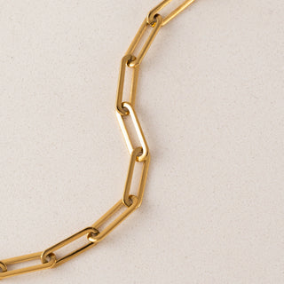 Gold chain necklace on a light beige background