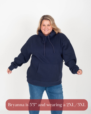 Woman wearing a navy blue hoodie and blue jeans on a white background
