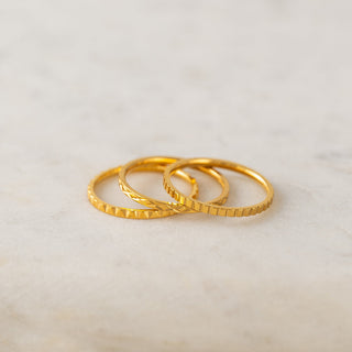 three gold rings laying on a table